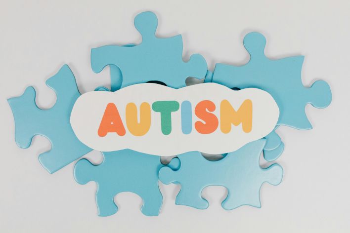 Puzzle Pieces with a Sign Saying "Autism"