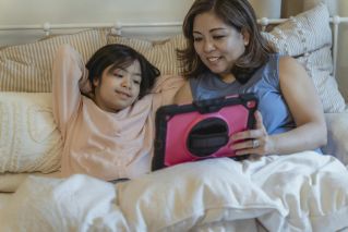 A Woman Showing a Girl a Tablet