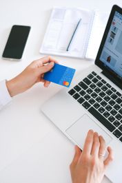 Person making an online purchase with a credit card on a laptop, showcasing modern ecommerce technology.